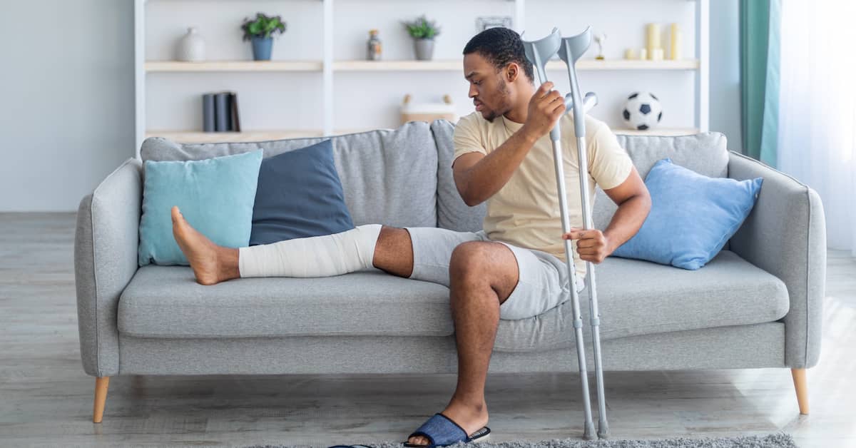 a personal injury victim with a broken leg rests on a couch | Coplan and Crane