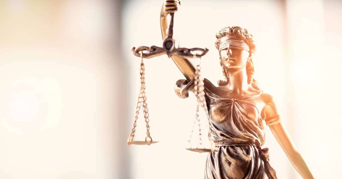 a scales of justice statue on a lawyer's desk | Coplan and Crane
