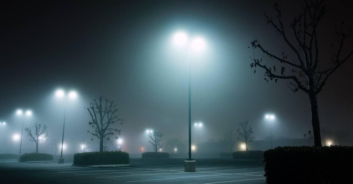 a misty parking lot at night | Coplan and Crane