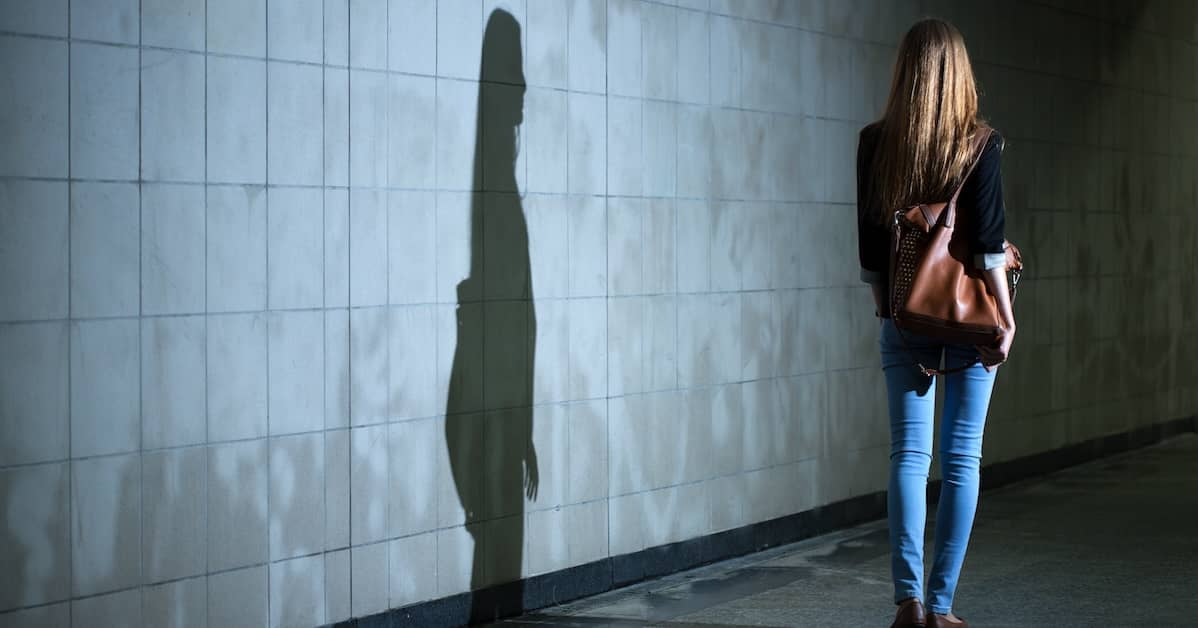 woman walks alone in dark car garage | Coplan and Crane